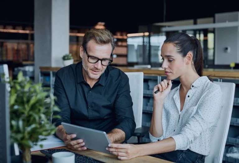 Two people reviewing a project on a tablet
